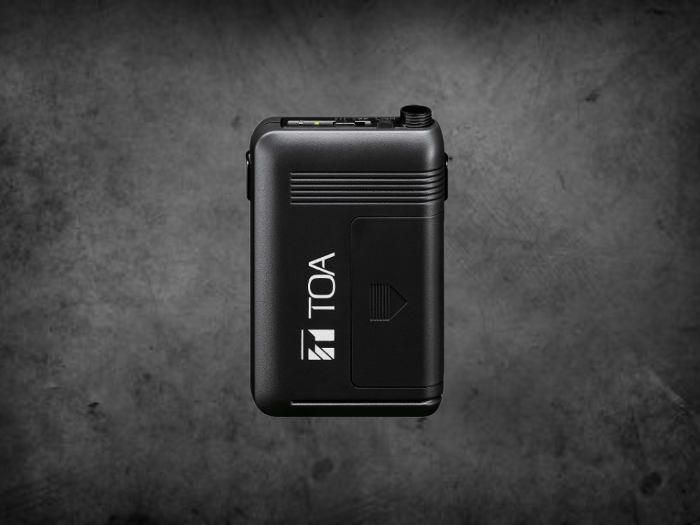 A black TOA WM-5325 Beltpack Transmitter with TOA branding shown on the front in bold white lettering, set against a grey background